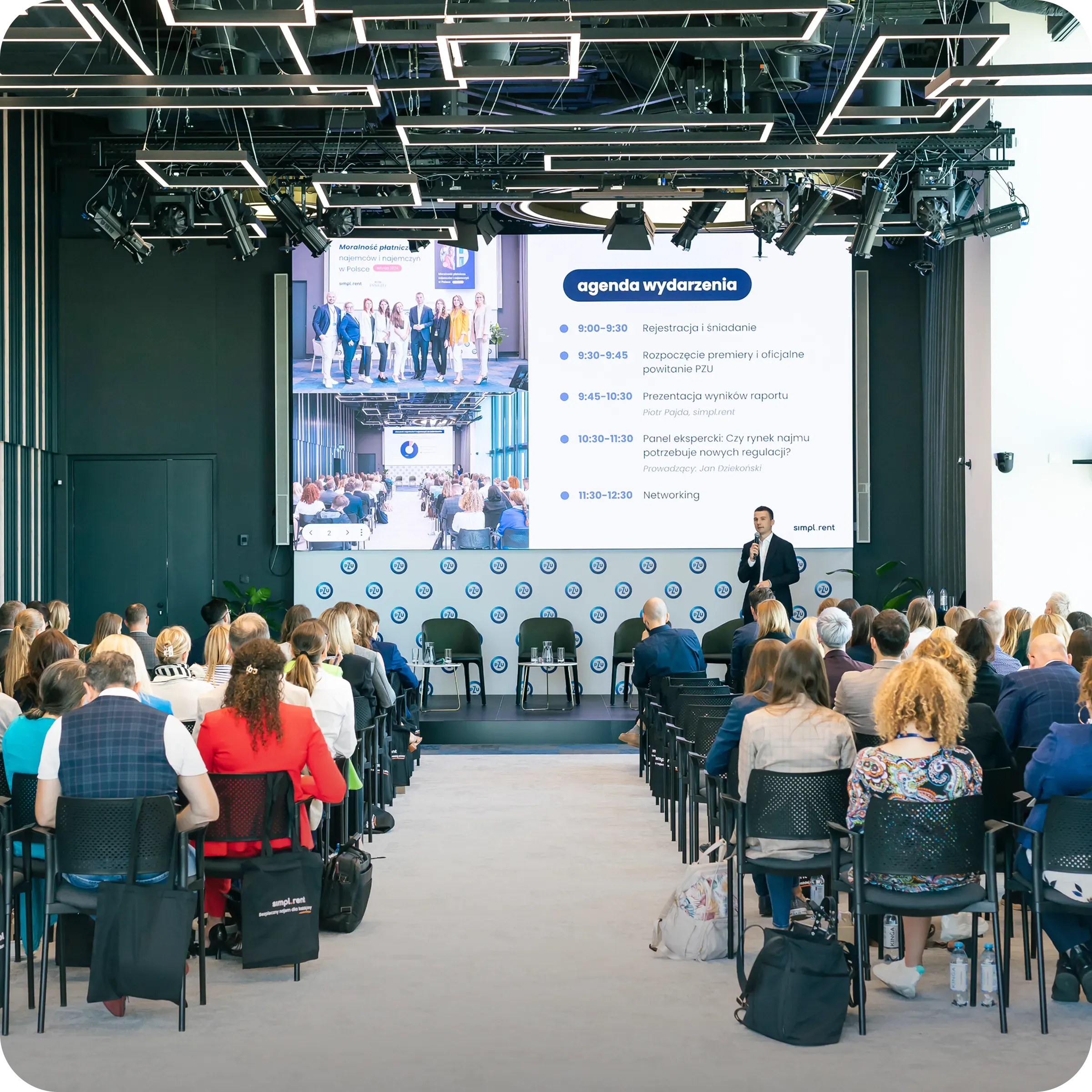 Konferencja branżowa z prezentacją na scenie i publicznością siedzącą na sali